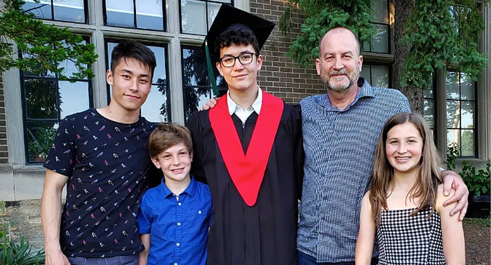Un gruppo di studenti e studentesse della Western Technical-Commercial School posa davanti all'edificio in mattoni con ampie finestre dopo la Graduation.