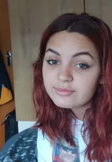 Porträt einer jungen Frau mit rotbraunen Haaren in einem Zimmer