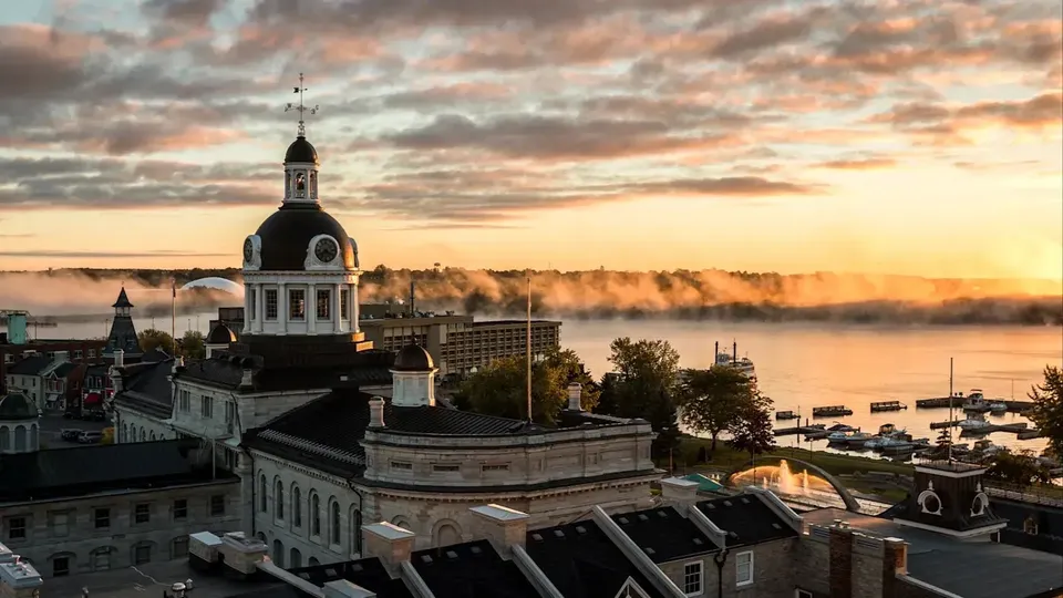 Il campanile storico è visibile al tramonto dalla École secondaire publique Mille-îles sopra un fiume nebbioso.