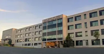 Fachada alargada de un instituto moderno de varias plantas al atardecer