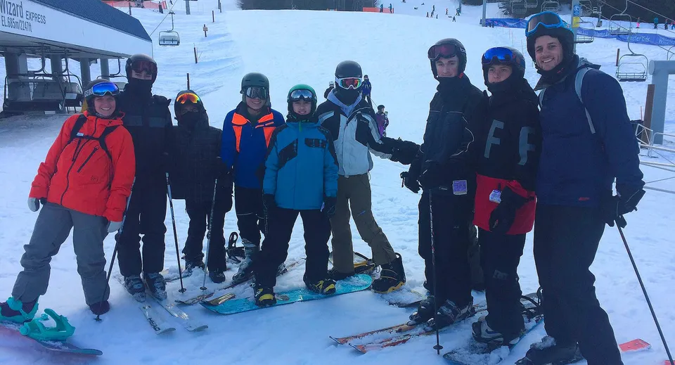 Un gruppo di studenti della Hugh Boyd Secondary School si trova su un pendio innevato con l'attrezzatura da sci.