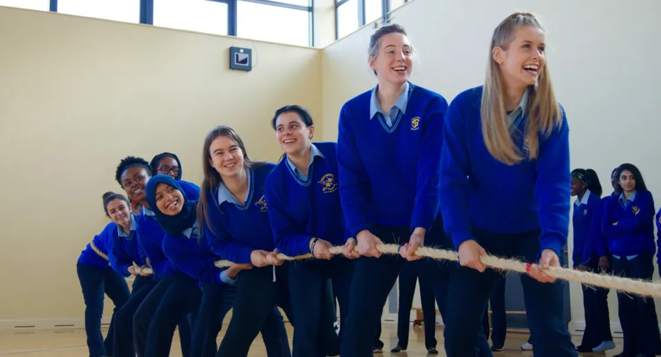 Un gruppo di studenti in divisa blu sorride insieme al Loreto College Mullingar.