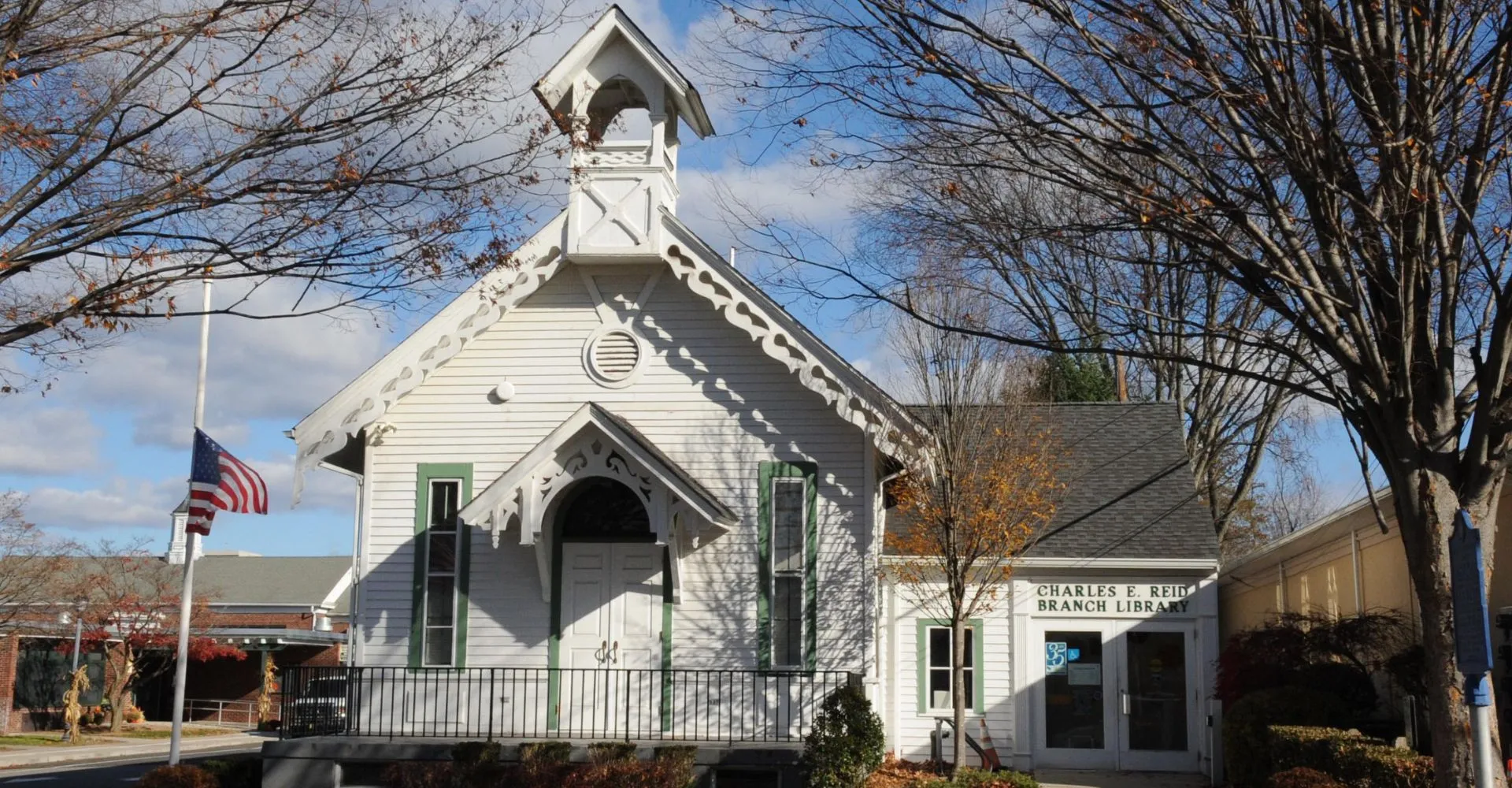 Una chiesa di legno bianca con campanile si erge sotto un cielo nuvoloso nel campus della Midland School.