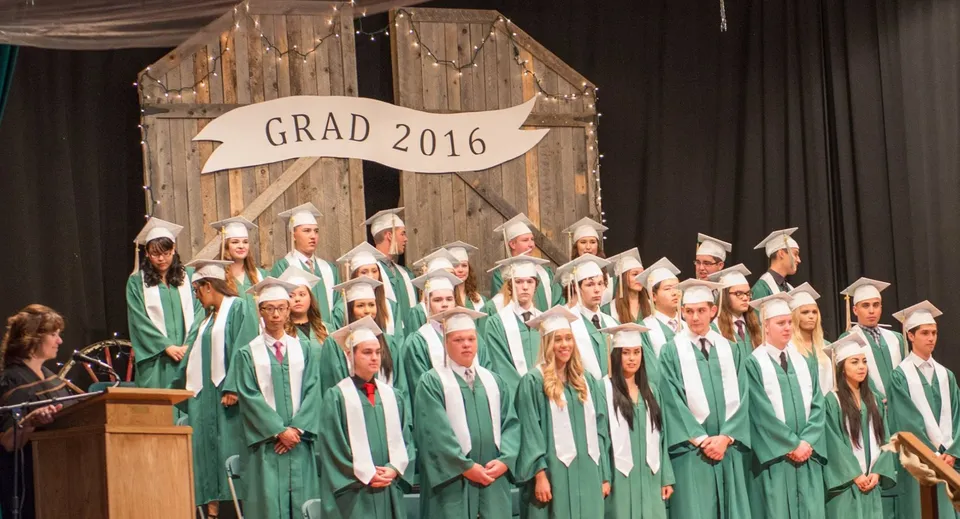 I diplomati della Bishop Mahoney High School sono sul palco in toga verde davanti a uno striscione con la scritta Grad 2016.