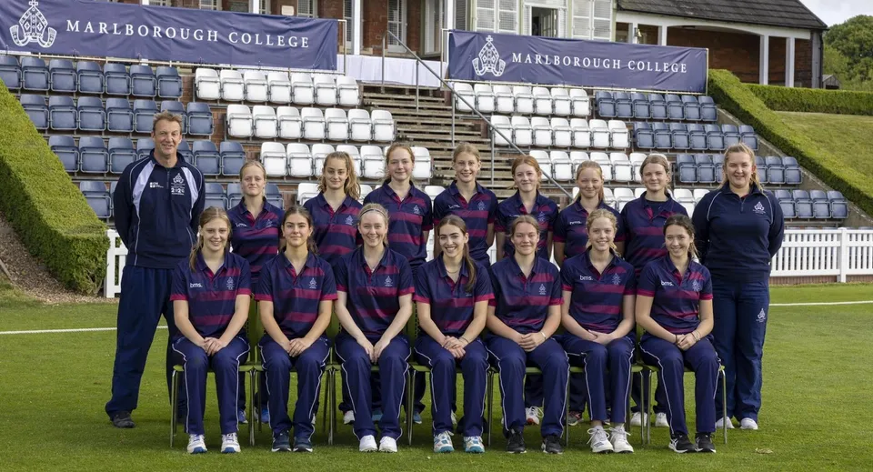 Un gruppo di giovani atlete posa sul prato davanti all'edificio del Marlborough College.