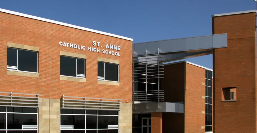 L'edificio moderno in mattoni della St. Anne Catholic High School si staglia contro un cielo azzurro e limpido.