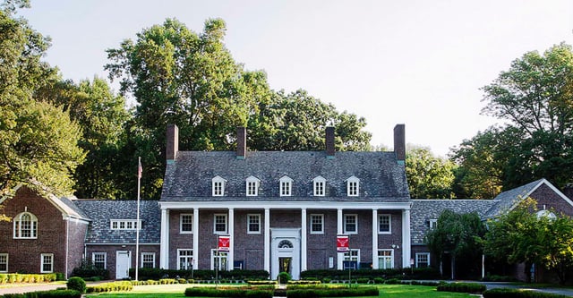 Ein kolonialstilartiges Herrenhaus steht auf dem Gelände der Princeton International School of Mathematics & Science umgeben von Bäumen und gepflegtem Rasen.