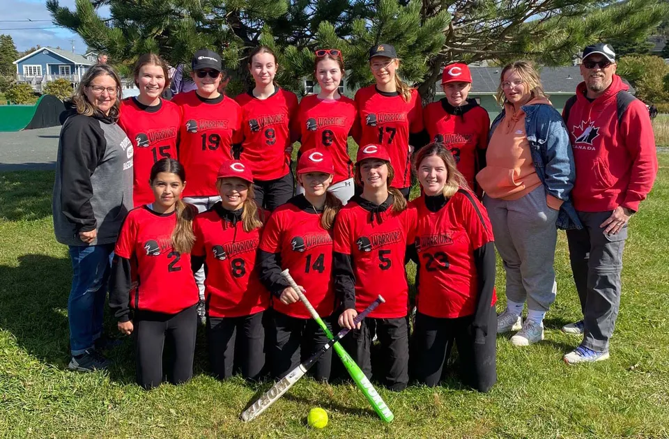 Un gruppo di giovani calciatrici in maglia rossa si trova sul campo in erba della Waterford Valley High School.