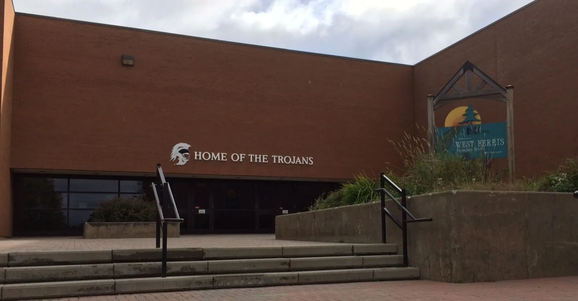 L'edificio marrone con la scritta Home of the Trojans nel campus della West Ferris School.