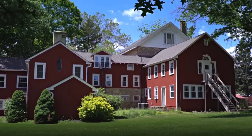 L'edificio in mattoni rossi è circondato da un paesaggio verde e si trova nel campus della Solebury School.