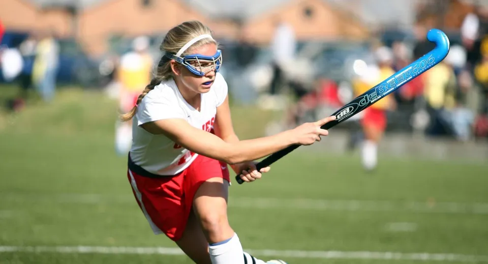 Un'atleta tiene una mazza da hockey sul campo da gioco della Rockport School durante una partita.