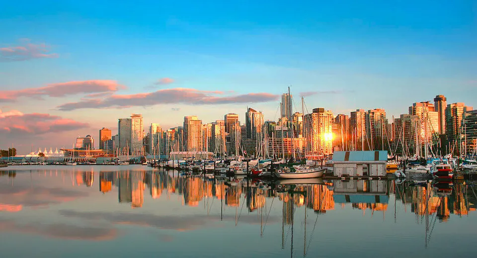 Un pittoresco paesaggio urbano con alti grattacieli vicino all'acqua nei pressi della Ernest Manning High School al tramonto.