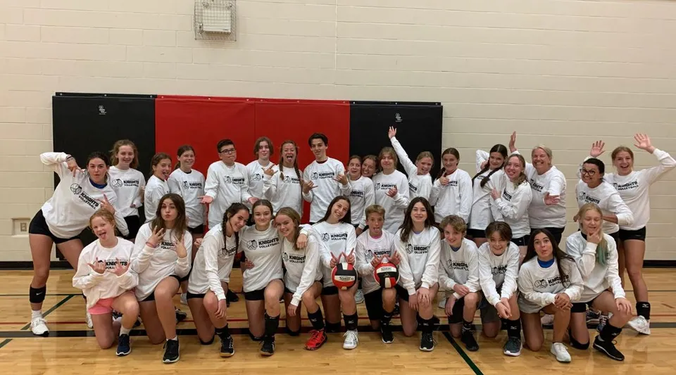 Un grande gruppo di giovani studentesse in divisa sportiva si riunisce nella palestra della North Grenville District High School.