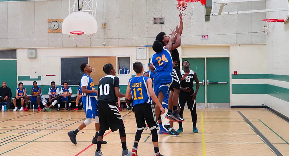 Studenti del L'Amoreaux Collegiate Institute giocano una partita di basket in palestra.