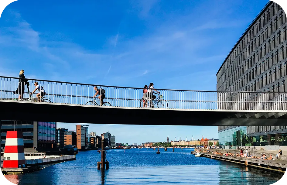 Collage di studentesse in bici e scorci di Copenhagen con scritte sui vantaggi delle vacanze studio