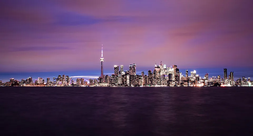Vista sullo skyline della città con la CN Tower al tramonto dietro il campus della John McGregor Secondary School.