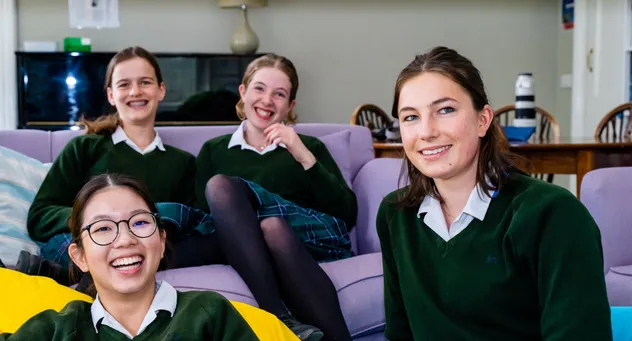 Vier Schülerinnen sitzen gemeinsam auf einem Sofa im Wohnbereich einer Schule in England