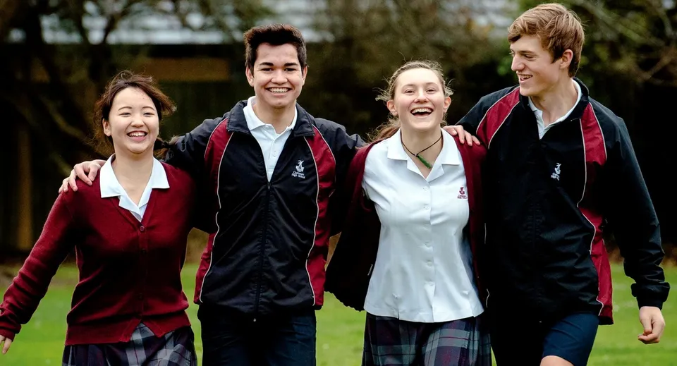Un gruppo di studenti si trova all'aperto nel campus della Cashmere High School su un prato con alberi sullo sfondo.