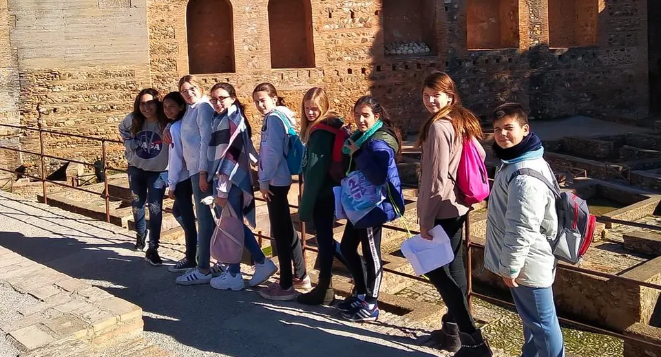Un gruppo di studenti e studentesse si trova davanti allo storico edificio in mattoni del Sage College.