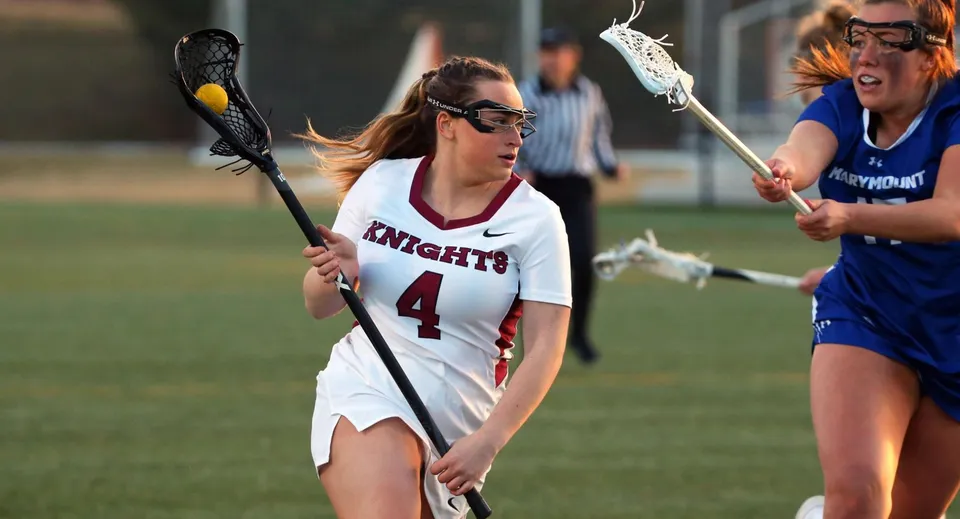 Una giocatrice di lacrosse della Marymount Academy International corre sul campo con la stecca.