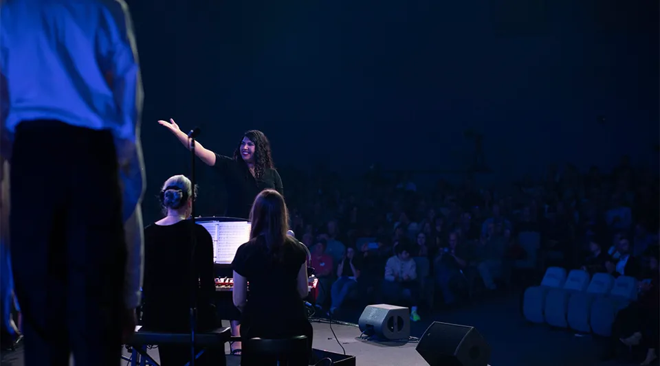 Una persona si esibisce sul palco davanti a un grande pubblico alle Gilbert Christian Schools.