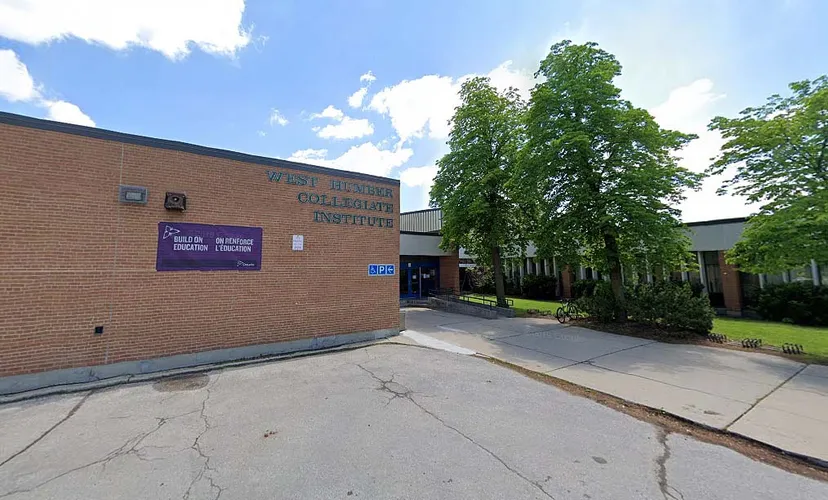 L'edificio in mattoni del West Humber Collegiate Institute è circondato da alberi e si trova lungo un viale lastricato.