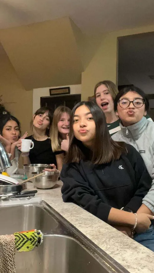 Grupo de chicas se divierte haciendo muecas en la cocina durante una velada juntas