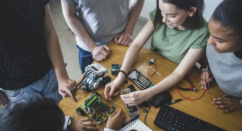 Studenti e studentesse del Castlepollard Community College lavorano insieme a un progetto di elettronica con diversi componenti.