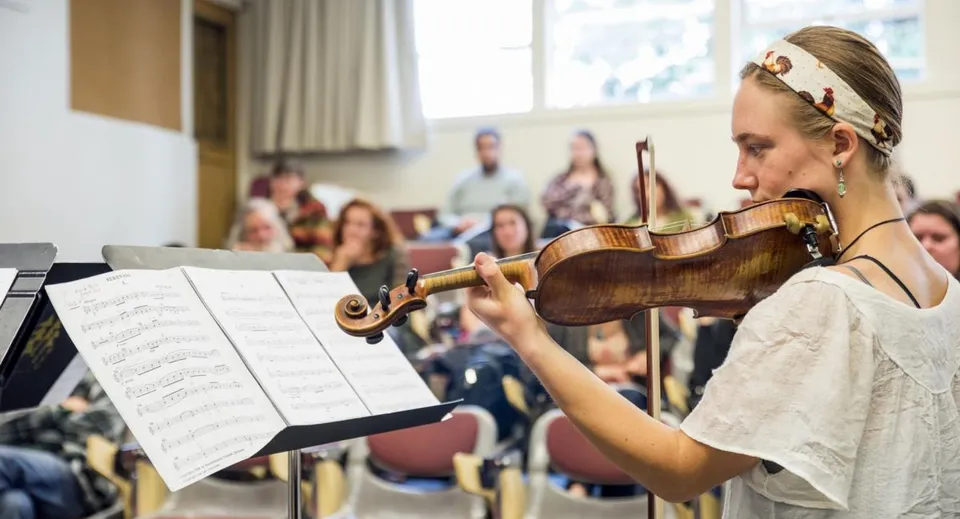 Una studentessa del Downingtown Area School District suona il violino davanti a un pubblico.