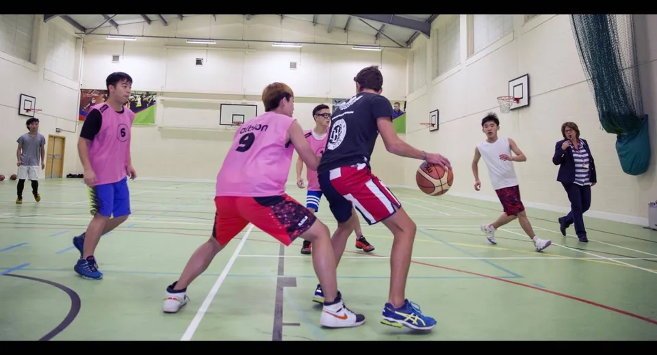 Studenti della Worthgate School Canterbury giocano a basket in palestra.