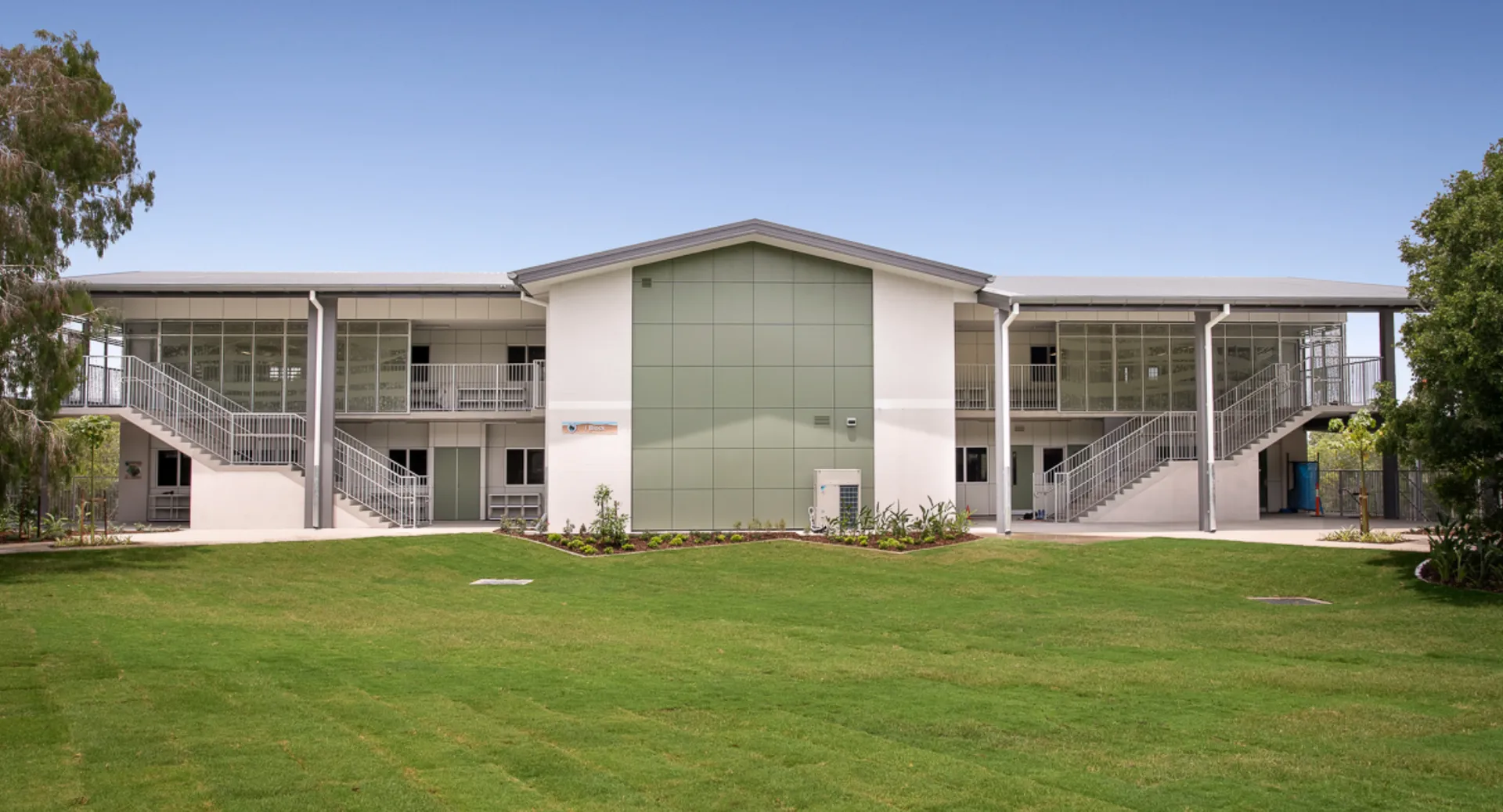 L'edificio moderno a due piani della Sunshine Beach State High School si trova su un prato ben curato ed è circondato da una verde vegetazione.