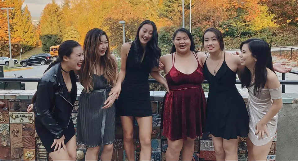 Un gruppo di giovani studentesse della Port Moody Secondary School posa davanti a un fogliame autunnale.