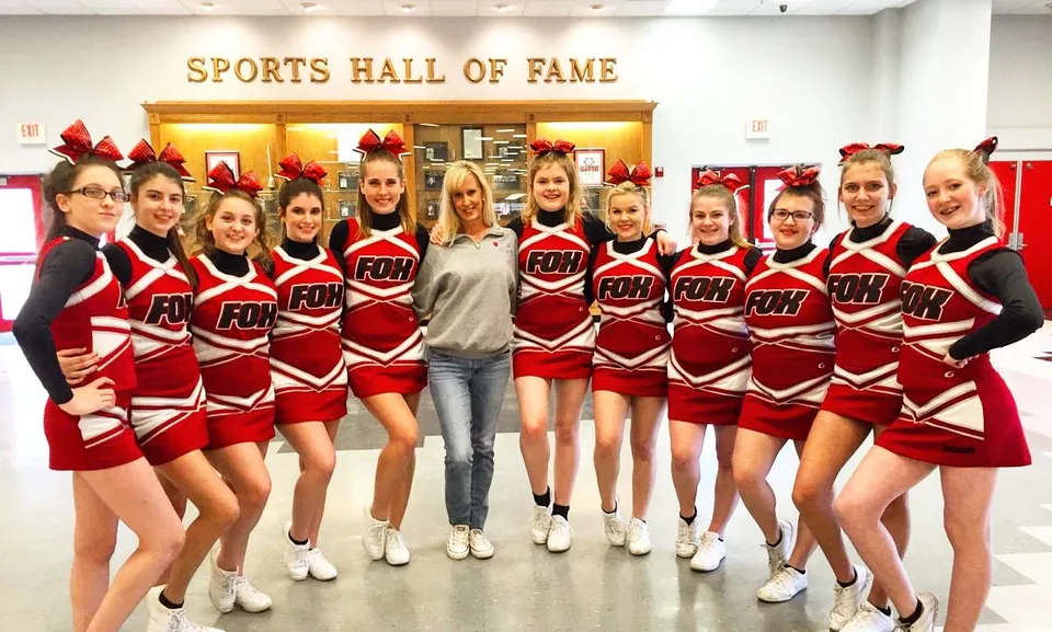 Un gruppo di cheerleader della O'Donel High School posa davanti al cartello della Sports Hall of Fame.