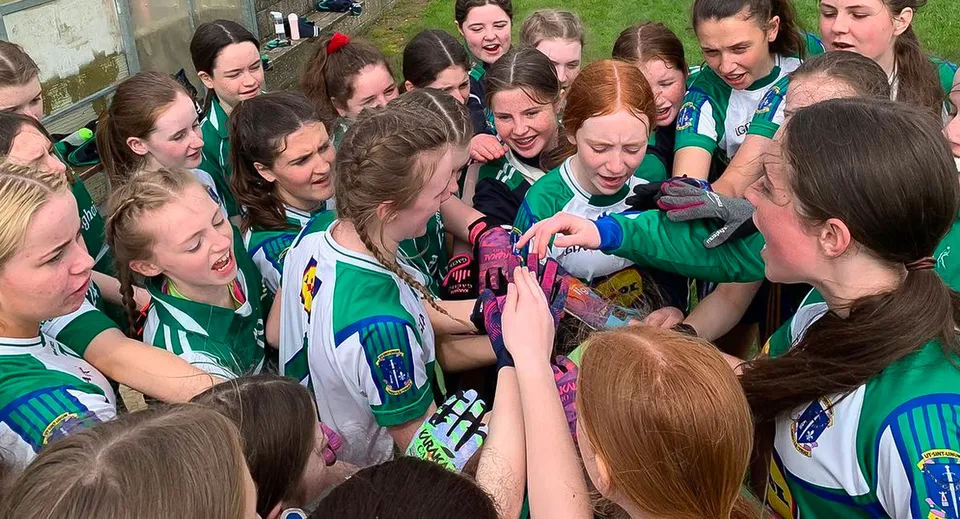 Studentesse della St. Louis Secondary School Dundalk festeggiano insieme sul campo sportivo.