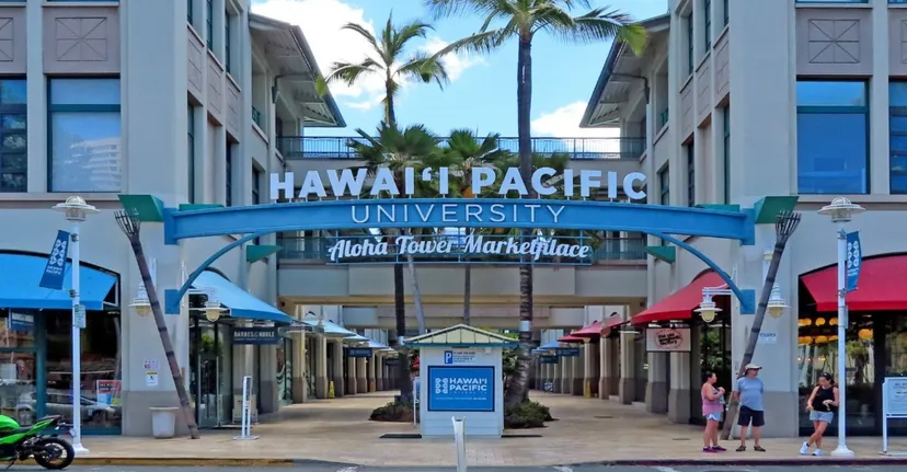 L'ingresso della Hawai'i Pacific University con un grande cartello e palme davanti all'Aloha Tower Marketplace.