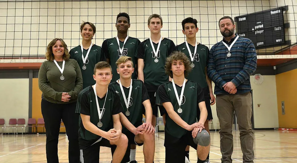 Un gruppo di studenti della Fernie Secondary School posa con le medaglie in una palestra.