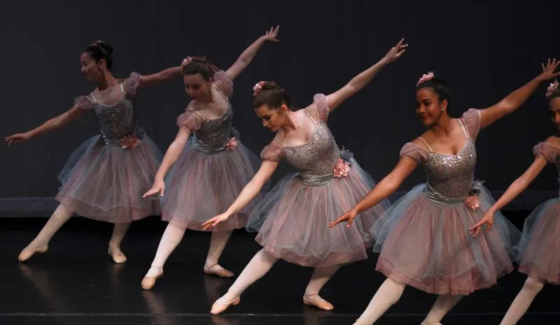 Un grupo de estudiantes de ballet interpreta una elegante pieza de danza en el escenario de la Miami Arts Charter School.
