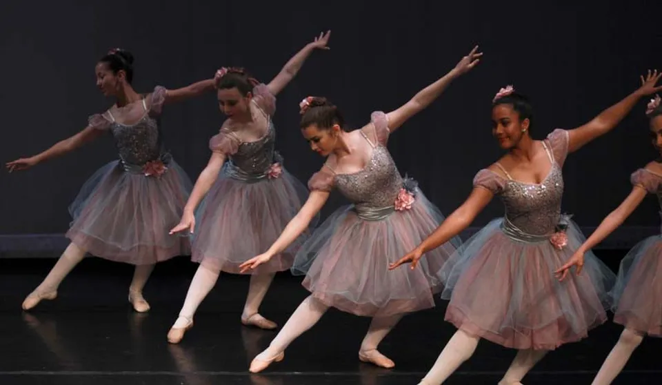 Un gruppo di studentesse di balletto esegue un'elegante coreografia sul palco della Miami Arts Charter School.