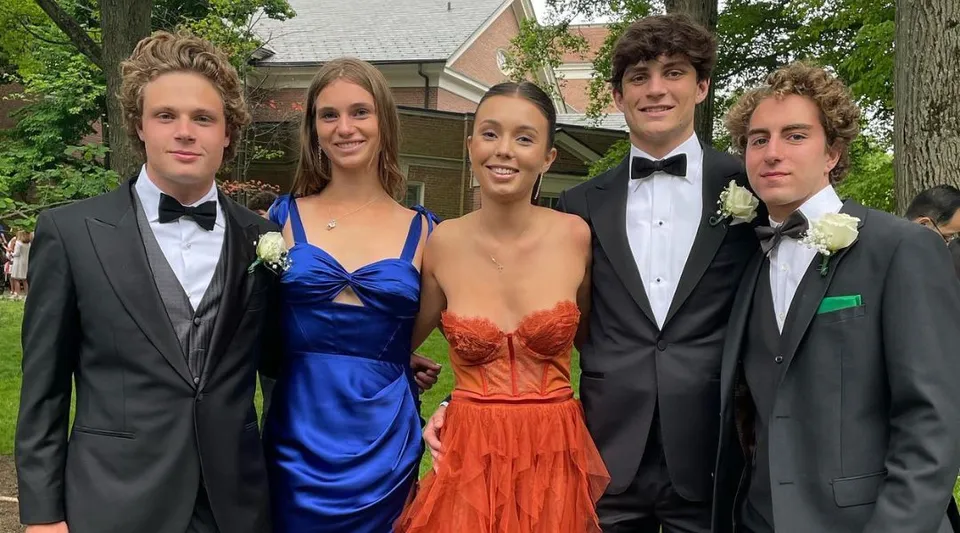 Un gruppo di cinque ragazzi in abiti eleganti davanti a un edificio residenziale nel campus della The Lawrenceville School.