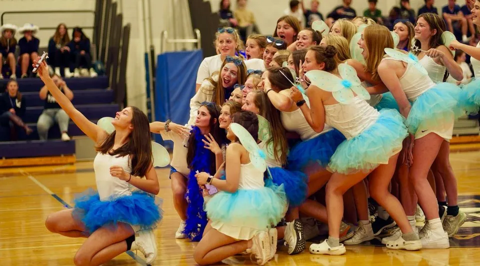 Le studentesse della Lake George Junior-Senior High School in colorati costumi da danza posano insieme sul palco.