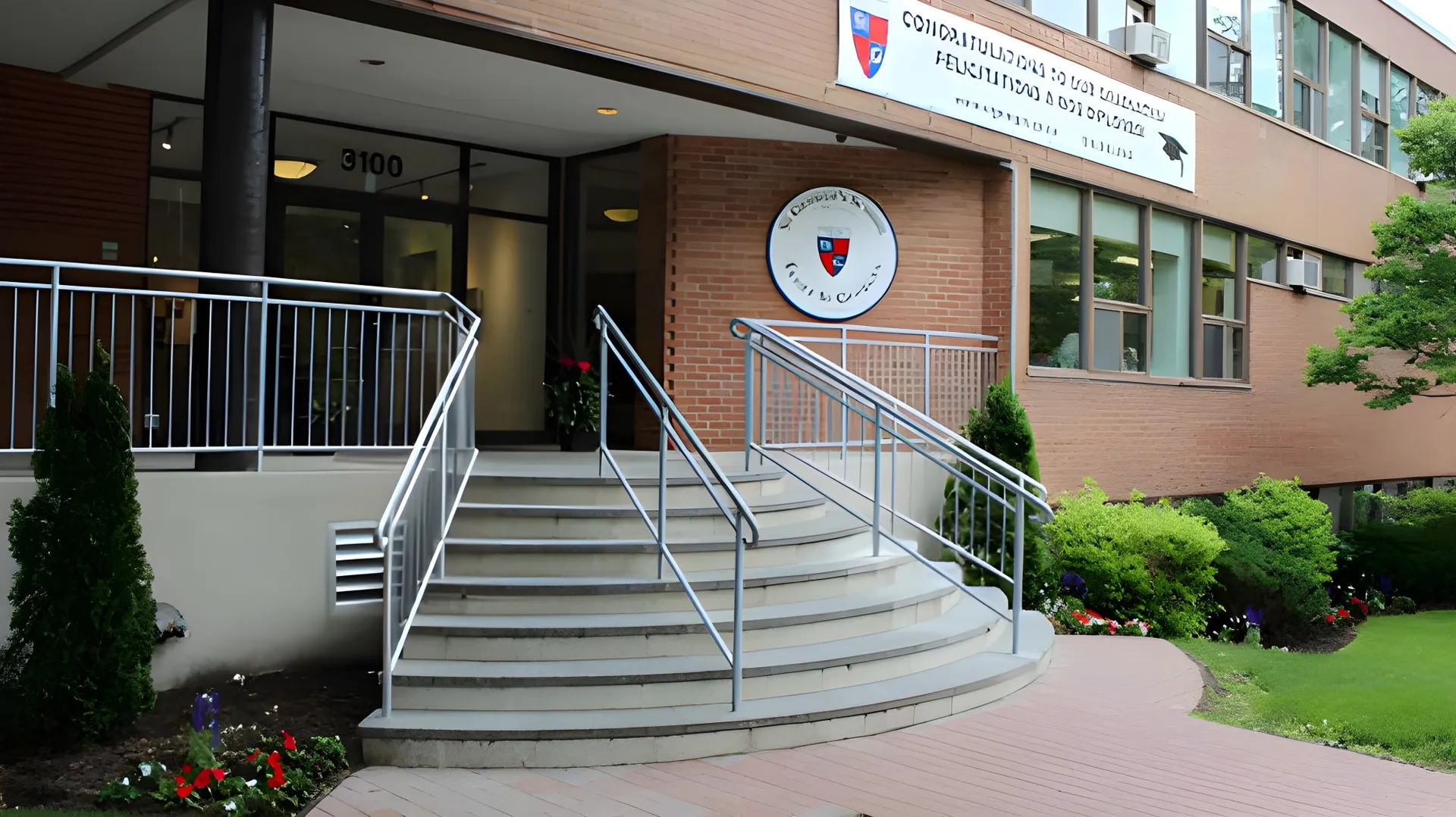 L'ingresso con le scale e un cartello sulla facciata in mattoni della St. George's School of Montreal.