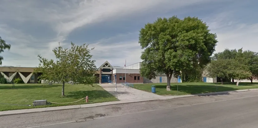 L'edificio colorato con tetto triangolare nel campus della Winston Churchill High School è circondato da alberi e da un'area verde.