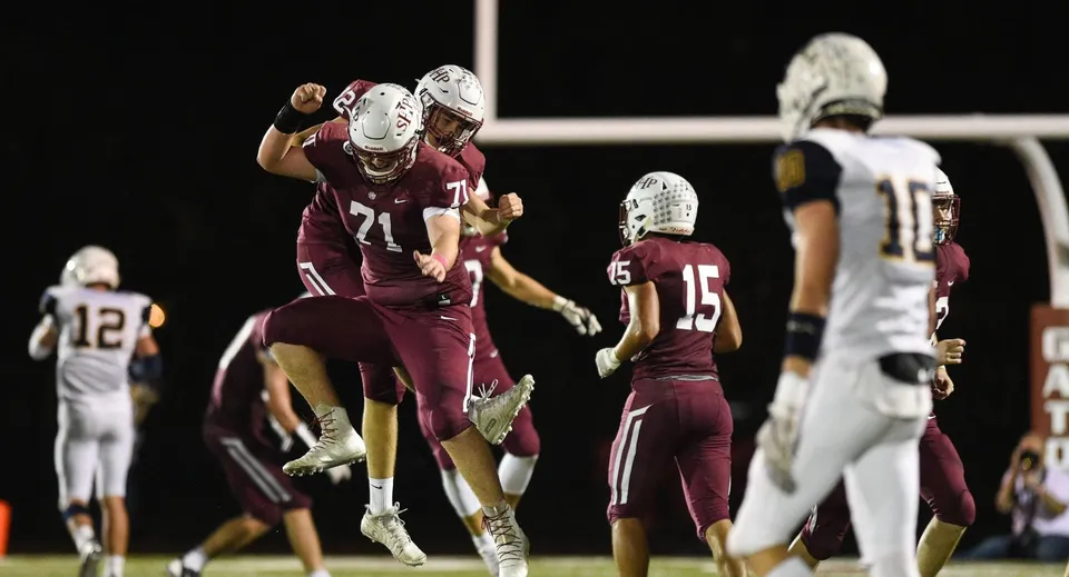 Studenti della Sacred Heart High School giocano una partita di football sul campo sportivo.