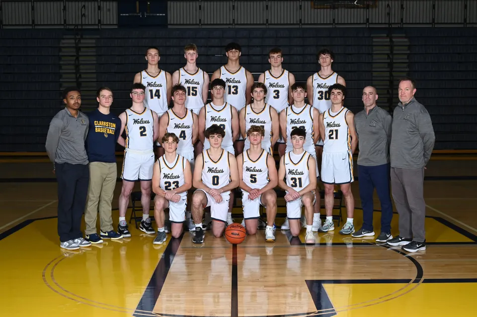 La squadra di pallacanestro della Clarkston High School posa per una foto di gruppo in una palestra.