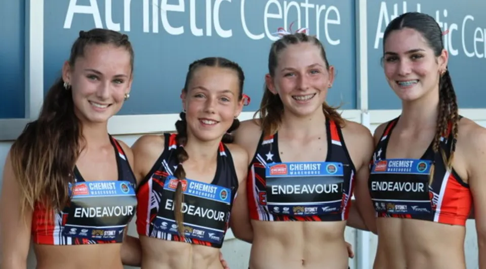Quattro studentesse in abbigliamento sportivo sono in piedi davanti all'Athletic Centre nel campus della Endeavour Sports High School.