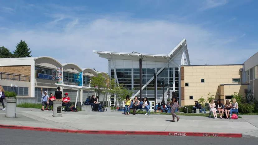 Studenti seduti su panchine davanti al moderno edificio della Chief Sealth High School.