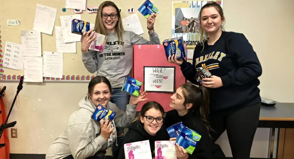 Un gruppo di studentesse mostra diversi cartelli durante un'attività alla Clayton Heights Secondary School.