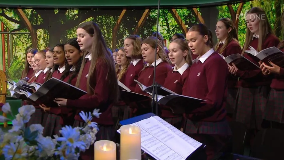 Gli studenti della Sacred Heart Secondary School a Tullamore sono insieme nel verde e cantano nel coro.