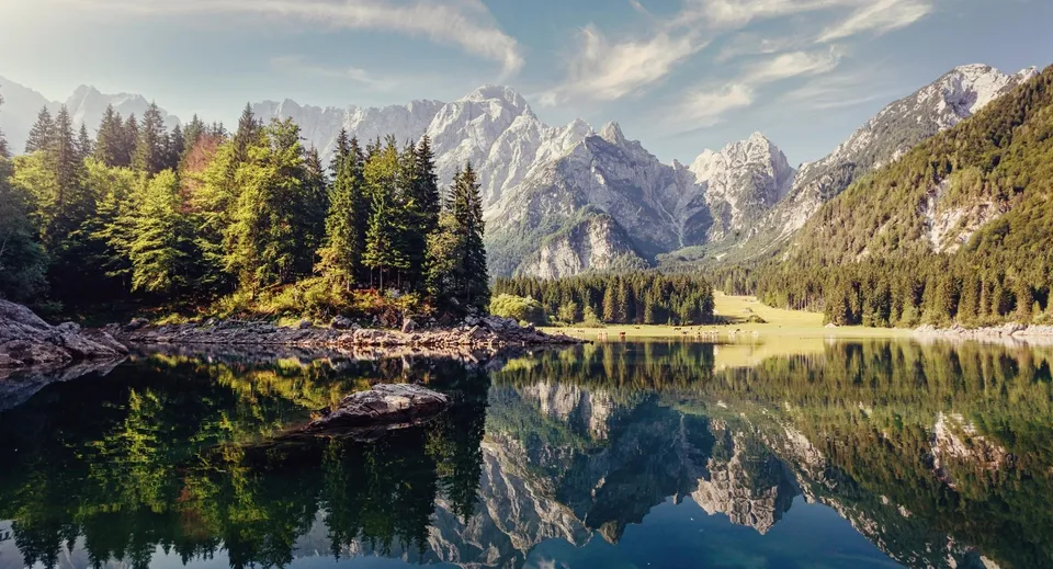 Il lago alpino con montagne innevate e foreste di conifere riflette il paesaggio nei pressi del John Abbott College.