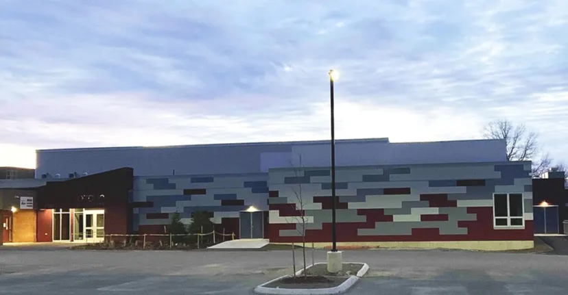 L'edificio della Regional School Unit N*26 con una facciata a motivi multicolori e un piazzale antistante.